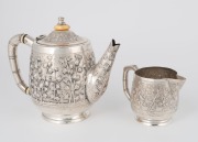 An antique Anglo-Indian silver teapot by Goopee Nath Dutt with repousse&nbsp;bamboo decoration and bamboo styled handle, signed to the base, "Goopee Nath Dutt,&nbsp;Bhowanipore, Calcutta", together with matching silver cream jug, (unsigned), circa 1890, (2 items), - 2