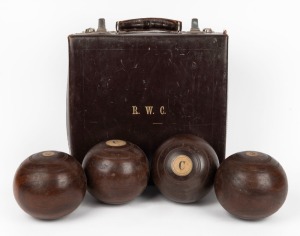 A set of four early timber lawn bowls in leather case, early 20th century.