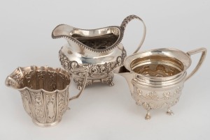 A Georgian sterling silver jug with repousse floral decoration, together with two English sterling silver cream jugs, (3 items), the largest 9.5cm high, 386 grams total