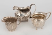 A Georgian sterling silver jug with repousse floral decoration, together with two English sterling silver cream jugs, (3 items), the largest 9.5cm high, 386 grams total