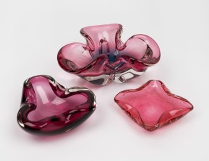 Three Murano&nbsp;glass bowls in cranberry and ruby, mid 20th century, the largest 20cm wide