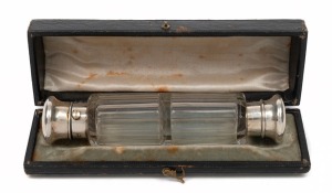 An antique clear faceted glass double-ended scent bottle with silver tops, housed in original fitted leather case, 19th century, 12.5cm wide