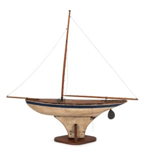 A vintage pond yacht with original blue and white painted finish on stand, early to mid 20th century, 92cm high, 95cm long overall
