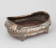 A Georgian sterling silver coaster with floral decoration and wooden base, made in London, circa 1825, 8cm high, 20cm wide, 326 grams including wooden base