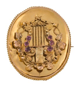 An antique Australian Colonial yellow gold oval brooch adorned with a lyre set with rubies, the&nbsp;reverse with mourning window, circa 1860s, 3.3cm high, 8.3 grams total