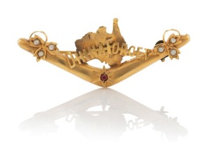 WILLIS & SONS of Melbourne "DINNA FORGET" Australian map and boomerang brooch in 9ct yellow gold, set with a garnet and seed pearls, 19th century, stamped "9" flanked by pictorial marks, ​​​​​​​5.2cm wide, 2.8 grams