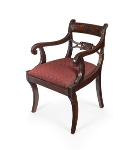An antique English Regency&nbsp;mahogany carver chair with reeded&nbsp;sabre&nbsp;front legs and scroll arm supports, pierced and carved mid rail&nbsp;and flame veneered&nbsp;and ebony strung top rail with wheat ear carved stiles, circa 1825, 81cm high, 51cm across the arms