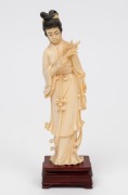 A Chinese carved ivory figure of Guanyin&nbsp;holding a fan and floral bouquet on rosewood plinth. Mid 20th century.20cm high.