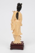 A Chinese carved ivory figure of Guanyin&nbsp;holding a fan and floral bouquet on rosewood plinth. Mid 20th century.20cm high. - 2