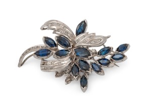 A vintage 9ct white gold brooch, set with 14 marquise cut blue sapphires, and grain set with 26 white diamonds. Accompanied with a Stephens & Miller of Camberwell, Melbourne insurance valuation for A$4,760. ​​​​​​​5.2cm wide, 12.6 grams