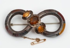 A antique Scottish silver brooch inlaid with agate and set with three cut citrine coloured stones, 19th century, 7cm wide
