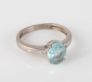 An 18ct white gold ring, set with a pale blue oval shaped sapphire, and a pair of shoulder mount diamonds, 3.20 grams.
