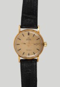 A gents gold wristwatch. Omega Geneve automatic dial with date aperture&nbsp;and baton hour indicators. Replaced Swiss manual movement, the&nbsp;case back marked 'DOXA' Swiss made 18K. 0.750. 20th century.36cm wide including crown.