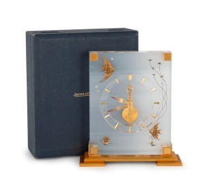 JAEGER LE COULTRE "Marina" mantle clock in lucite case inset with angel fish and seaweed decoration, standing on a gilded brass plinth base. Dial with gilt hands and baton numeral and skeletonised&nbsp;gilt inline&nbsp;movement, jewelled,&nbsp;with balance wheel, lever 
