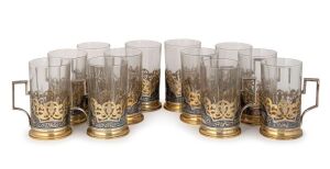 A set of 12 vintage Russian silver Kubachi tea glasses with silver gilt niello holders. Kokoshnik mark Moscow 875 with additional maker's mark.20th century, (one glass liner replaced)12.5 cm high, the silver holders 1084&nbsp;grams total&nbsp;