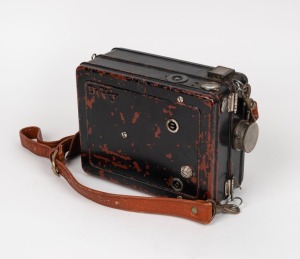 DEVRY: Circa 1926 35mm hand-cranked Devry 'Lunchbox' Standard Portable Camera, with carry strap, internally-stored Cine-Velostigmat f3.5 lens [#238841], and locking lens cap.