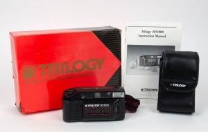 TRILOGY: 3D1000 stereo 35mm camera, c. 1990s, in maker's box with leather pouch and instruction booklet.