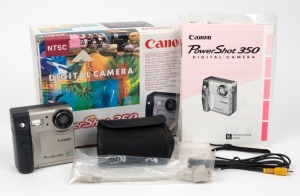 CANON: PowerShot 350 digital camera, c. 1997, in maker's box with leatherette case, memory card, instruction booklet, and other elements.