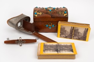 STEREOVIEW CARDS: A collection of 47 British and German views housed in an attractive antique burr walnut dome top casket with Gothic gilt metal fittings and turquoise&nbsp;paste adornments; together with an antique viewer.