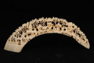 A vintage Chinese carved hippopotamus tooth bridge with figures in landscape, 19th/20th century, ​​​​​​​22cm long