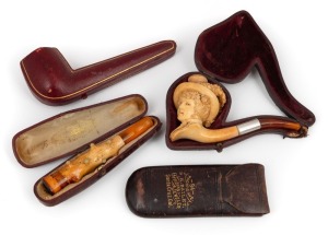 Two antique carved Meerschaum pipes&nbsp;with amber mouth pieces, both housed in original plush leather fitted cases; together with an antique leather spectacle case and a pipe case, 19th century
