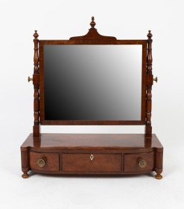 An antique English Regency bow front mahogany and ebony strung toilet mirror standing on turned bun feet with&nbsp;adjustable mirror, turned supports and central pediment with turned finial, circa 1835, 69cm high, 60cm wide, 26cm deep.