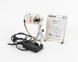 ASAHI KOGAKU: Pentax Optio I-10 digital camera, c. 2010, with D-BC92 Battery Charger, instruction booklet, wrist strap, and miniature tripod.