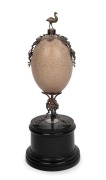 An antique emu egg ornament with silver plated mounts, emu finial and ebonised timber base, 19th century, 33cm high