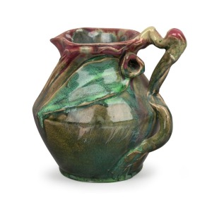 275 · REMUED pink and green glazed pottery jug with blue highlights, decorated with applied gumnuts and leaves, incised "Remued 192", 16cm high