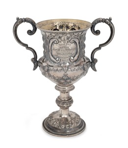49 · An antique presentation sterling silver two handled trophy cup with repousse decoration and engraved dedication "Special Prize For Red Wine, The Gift Of The Daily News, Awarded To, Otto Fring Esq.r, At The Castlemaine Grain & Wine Show, March 17th 1868", made by George Unite of Birmingham, circa 1865, 23cm high, 376 grams.
