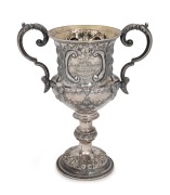 An antique presentation sterling silver two handled trophy cup with repousse&nbsp;decoration and engraved dedication "Special Prize For Red Wine, The Gift Of The Daily News, Awarded To, Otto Fring Esq.r, At The Castlemaine Grain & Wine Show, March 17th 1868",&nbsp;