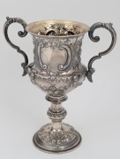 An antique presentation sterling silver two handled trophy cup with repousse&nbsp;decoration and engraved dedication "Special Prize For Red Wine, The Gift Of The Daily News, Awarded To, Otto Fring Esq.r, At The Castlemaine Grain & Wine Show, March 17th 1868",&nbsp; - 2