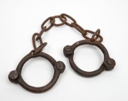 CONVICT LEG IRONS, early riveted construction with remains of broad arrow stamps, 18th/19th century, ​​​​​​​70cm wide. - 2