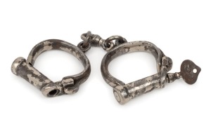 CONVICT HANDCUFFS, heavy duty example with original key and remains of nickel plating, mid 19th century, 24cm wide