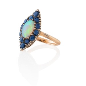 An antique Australian rose gold ring, set with a solid polished opal surrounded by blue sapphires, 19th century, 7 grams total