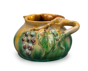 REMUED pottery jug with applied grape decoration, incised "Remued, Hand Made, 173/LM", 11cm high, 18cm wide