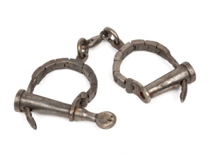 Antique articulated handcuffs with key, 19th century, 30cm wide.