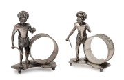 A pair of antique Australian silver plated napkin rings with Aboriginal hunting figures standing on Australian map bases, retailed by SIMONSEN of Melbourne, 19th/20th century, 9cm high.