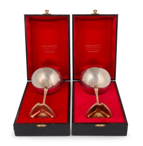 STUART DEVLIN pair of "SYDNEY OPERA HOUSE SILVER COMMEMORATIVE GOBLETS 1973," each with a gilt wash bowl and stem, raised on a tripartite foot embossed with scenes of the old fortifications, the Sydney Opera House under construction and completed. Both housed in original red velvet and satin lined boxes, 15cm high, 490 grams total.