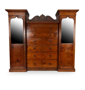 An early Colonial Tasmanian&nbsp;Beaconsfield&nbsp;wardrobe. The central section fitted with six graduated drawers with original&nbsp;knobs and lozenge&nbsp;escutcheon inlay, the upper frieze with discreet&nbsp;long drawer and scroll carved pediment. Full length hanging to the cu