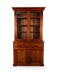 An antique Australian cedar two door secretaire library bookcase with applied shield shaped doors to the base flanked by tapered pilasters, the secretaire drawer fitted with cedar drawers and huon pine edged pigeonholes, the upper section with matching pi