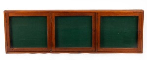An antique Australian cedar three door wall mounted noticeboard cabinet, circa 1900, ​​​​​​​48cm high, 152cm wide, 6.5cm deep
