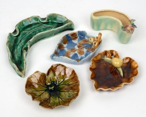 PEGGY HUTCHINSON pottery leaf dish with snail, CHRISTINE A. PECKET pottery leaf dish, H. MILLER leaf dish with gumnuts, HARVEY SCHOOL green glazed pottery leaf dish and a flower trough with applied floral decoration (5 items), the largest 16cm wide