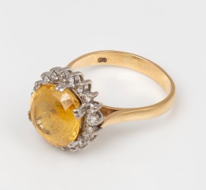 A vintage yellow gold ring, set with large yellow topaz surrounded by brilliant cut white diamonds, 9 grams
