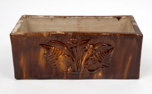 253 · McHUGH pottery trough with embossed fern and floral decoration to front and back, mottled brown glaze with cream interior, incised "H. McHugh, Tasmania", 12cm high, 13cm wide