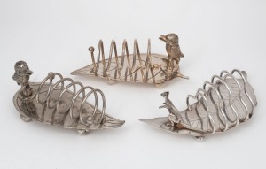 76 · Three antique Australiana silver plated toast racks, two with kookaburras, the other with kangaroo, all mounted on gum leaf bases, circa 1900, ​​​​​​​the largest 19cm wide.