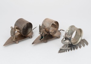92 · Three assorted antique silver plated napkin rings with gum leaf or fern bases, decorated with kangaroo and emus, 19th/20th century, the largest 6cm high, 12cm wide.