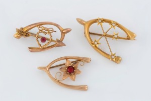 Three antique Australian 9ct gold wishbone brooches, set with seed pearls and red stones, 19th/20th century, the largest 3.5cm wide, 6.5 grams total.