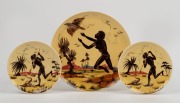 GUY BOYD group of three hand-painted pottery plaques with Aboriginal scenes on yellow ground, each incised "Guy Boyd, Australia", 24cm and 15.cm diameter