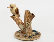 A pottery kookaburra on branch sculpture with applied floral decoration, in the the manner of Hatton Beck, 14.5cm high